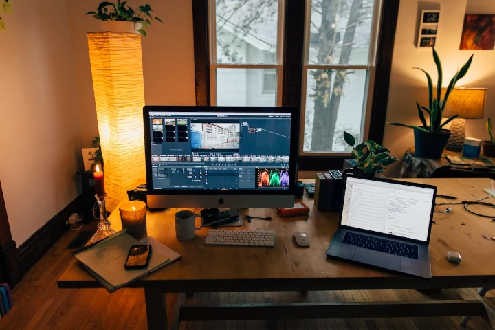 A desk with two laptops and a lamp